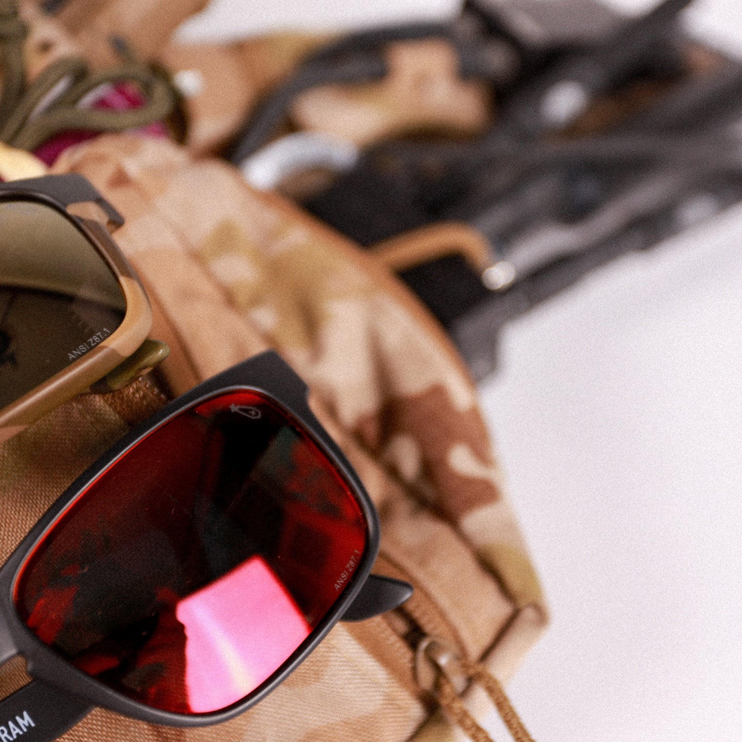 Sunglasses with red lenses on a camouflage-patterned surface