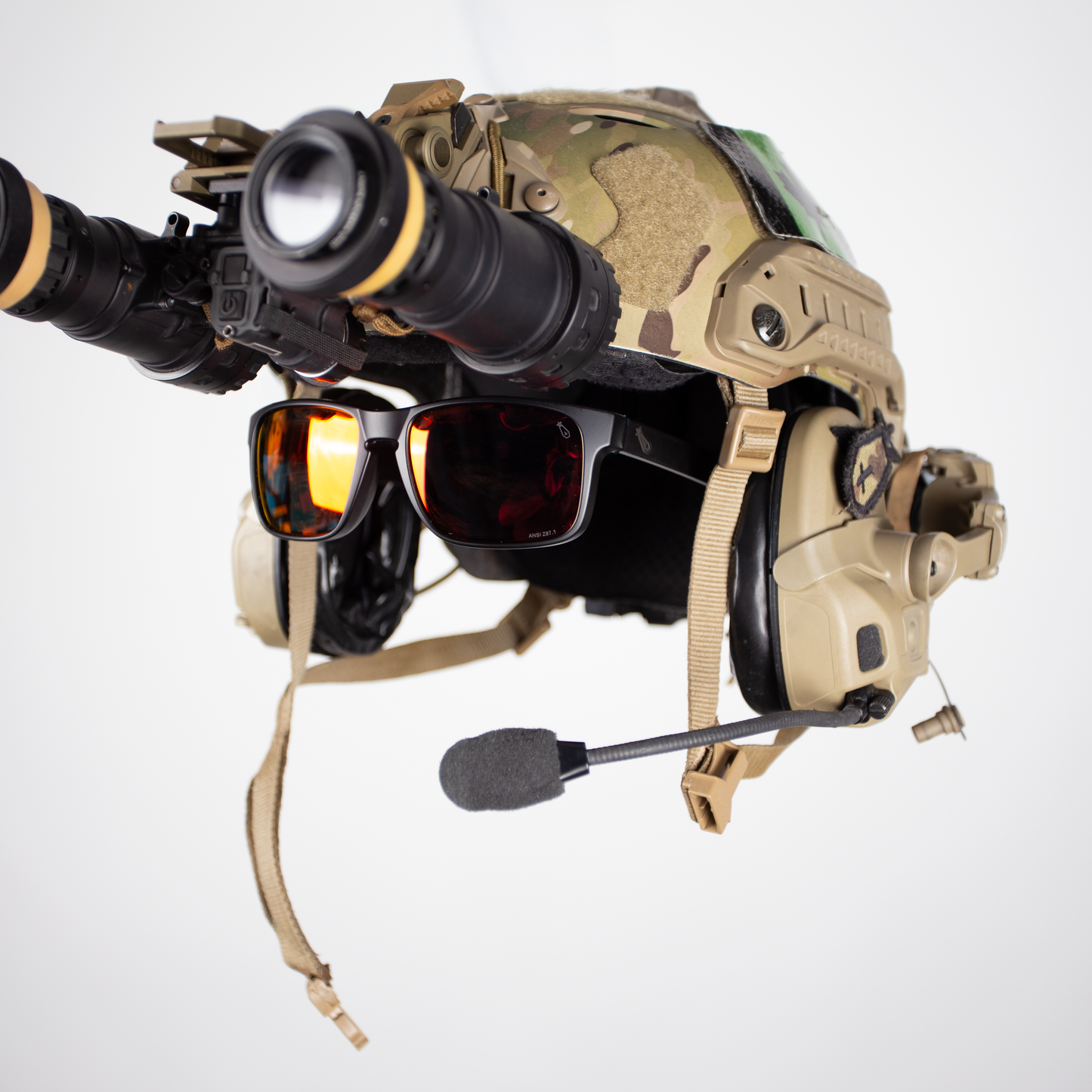Tactical helmet with night vision goggles and communication headset on a light gray background