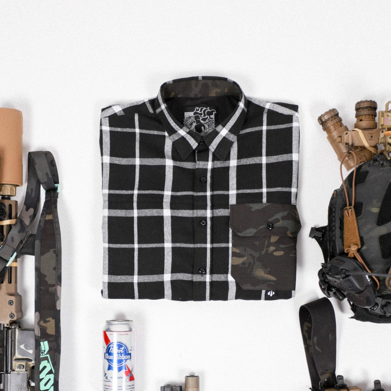 Black and white checkered shirt with camouflage accents, rifle, backpack, and energy drinks on a white background
