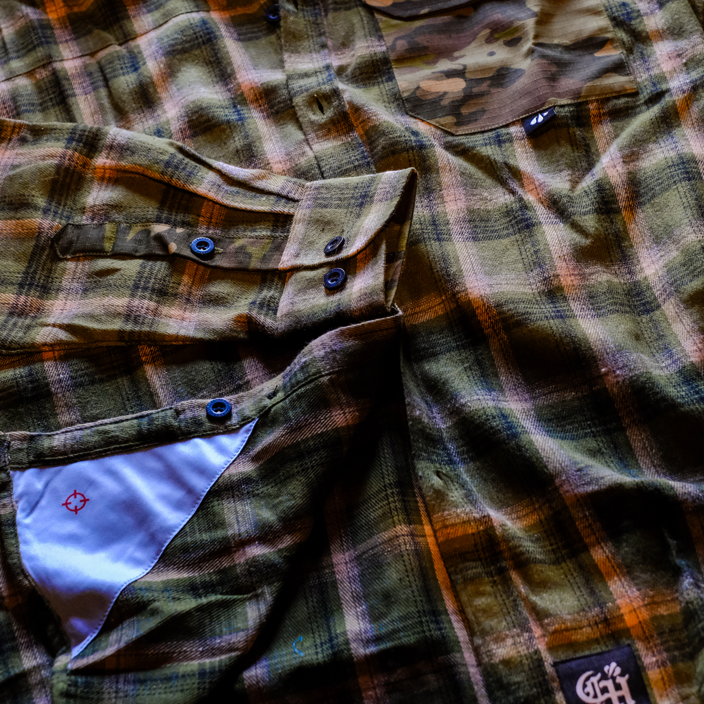 Plaid shirt with visible brand logos on a textured surface