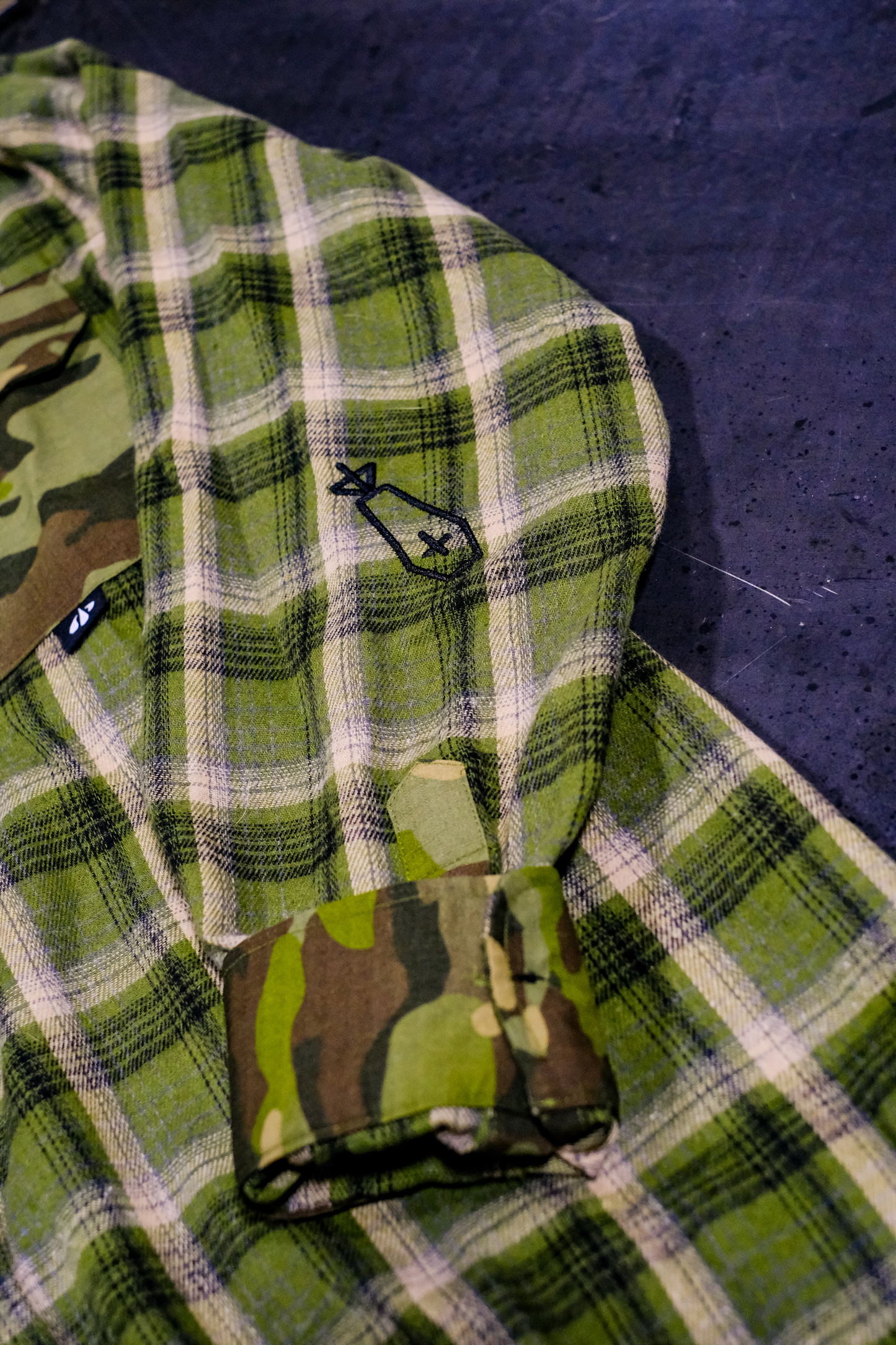 Green plaid fabric with camouflage pattern on a dark surface