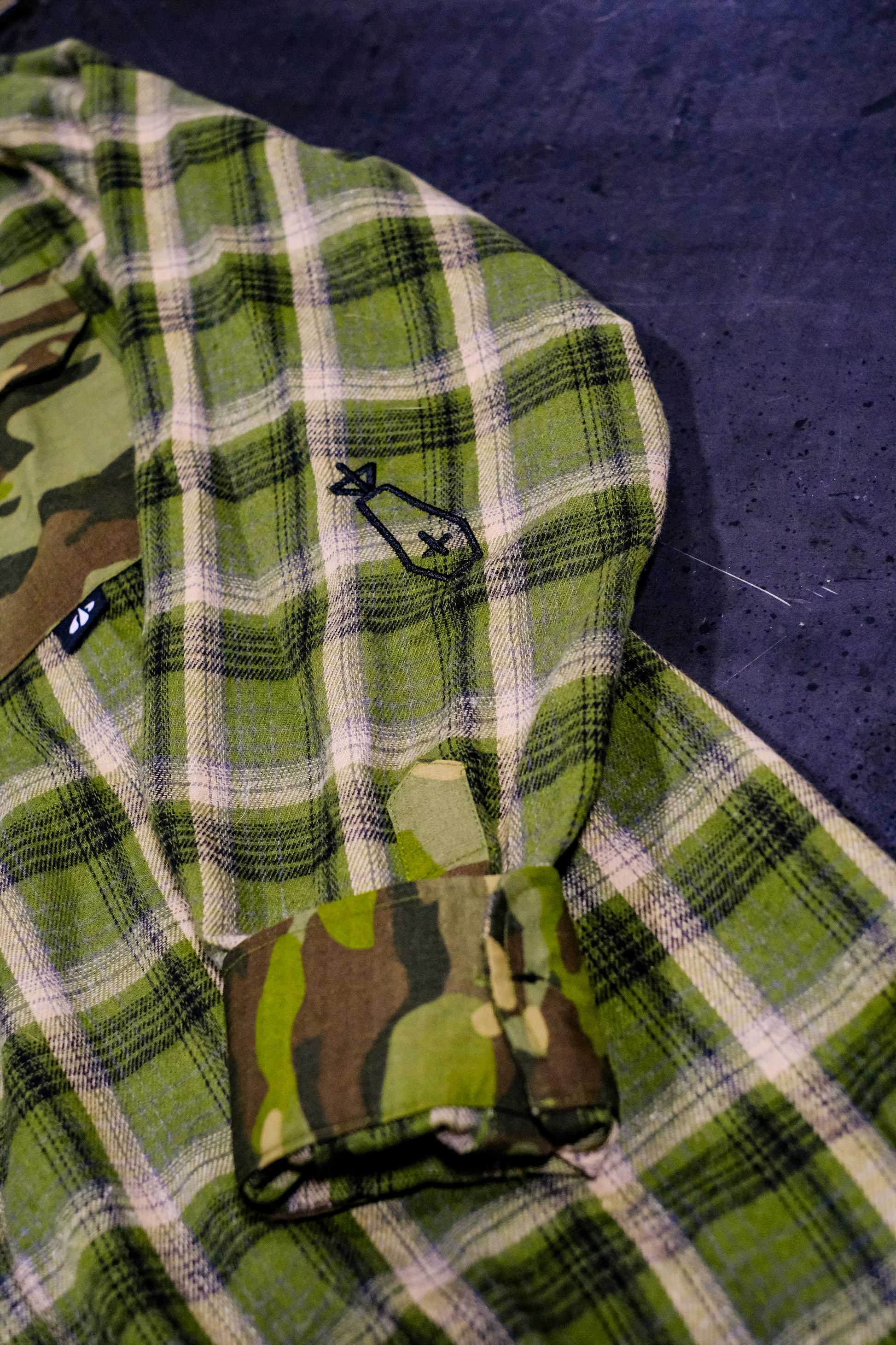 Green plaid fabric with camouflage pattern on a dark surface